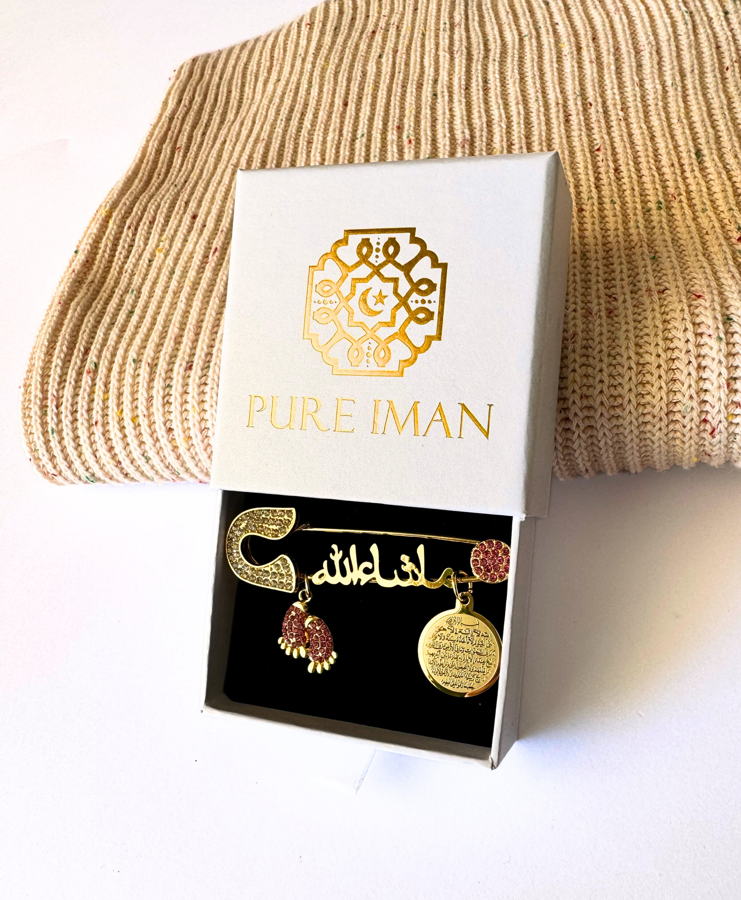 Ayatul Kursi pin and beige baby blanket, which can be found in our Islamic baby gift boxes